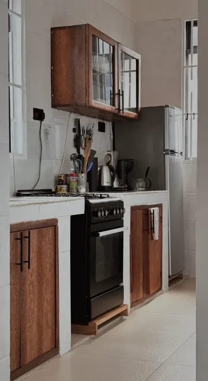 Shared kitchen with gas oven, fridge and wooden cupboards