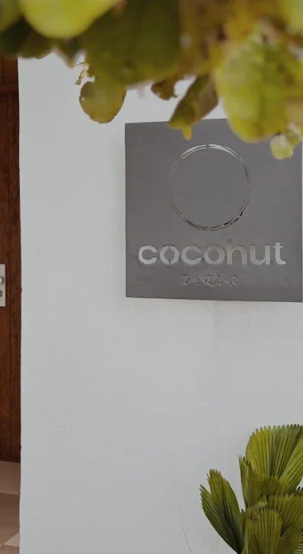 Cocohut metal sign on the white garden wall