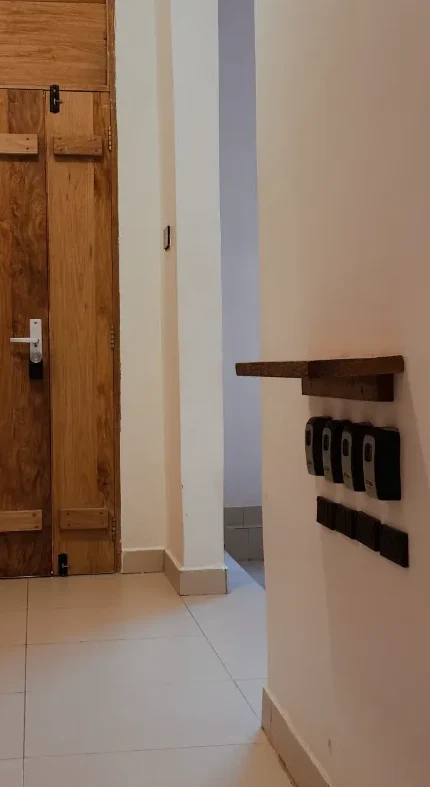 Hallway with a wooden room door and key boxes on the wall