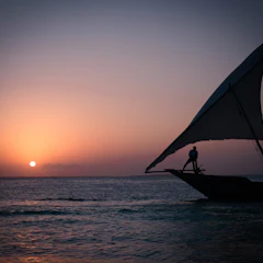 Traditional dhow sailing at sunset